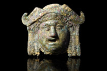 Ca. 100 AD.
A bronze mount, hollow beneath its surface, emerges as a striking half-rounded representation of a goddess's visage. The countenance of th...