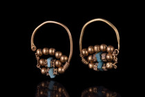Ca 11th-12th century AD.
A matched pair of gold earrings, each an wire elongated hoop beginging with a tear drop turquise cobuchon and terminating to ...