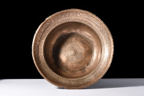 Ca. 18th-19th century AD.
An ablution basin formed from brass with a squat, globular shape and a widely flaring rim. The wide flange is embellished wi...