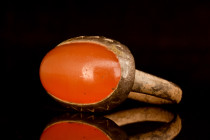 Ca. 600-800 AD.
A bronze ring adorned with a captivating red stone. It comprises a flat section shank and a large bezel cell with an intricately desig...