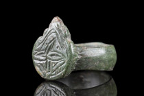 Ca. 500-600 AD.
A two-piece bronze finger ring of a plain, flat-section hoop and an applied shield-shaped bezel with convex sides and serrated upper p...