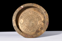 Ca. 1100-1200 AD.
A copper inlaid brass dish with a broad and flat base, accompanied by low straight walls that gracefully ascend to a flattened rim. ...