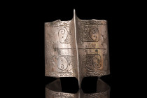Ca. 1100-1200 AD.
An open-type bracelet featuring a prominent central ridge and reinforced edges, giving it a bold and striking appearance. The exteri...