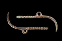 Western Asia, ca. 1200-700 BC.
A rare pair of bronze amulets, each characterized by a round-section shank with ribbed features on one end and a claw-s...