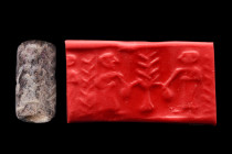 Ca. 2100-2000 BC.
Cylinder seal of dark stone. Two standing figures picking dates from palm; terminal bush. Condition good. Accompanied by a signed sc...