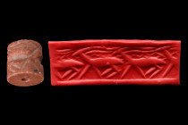Ca. 3000 BC.
Cylinder seal of pink stone. Frieze of three walking horned animals with something under their horns. Condition fine. Accompanied by a si...