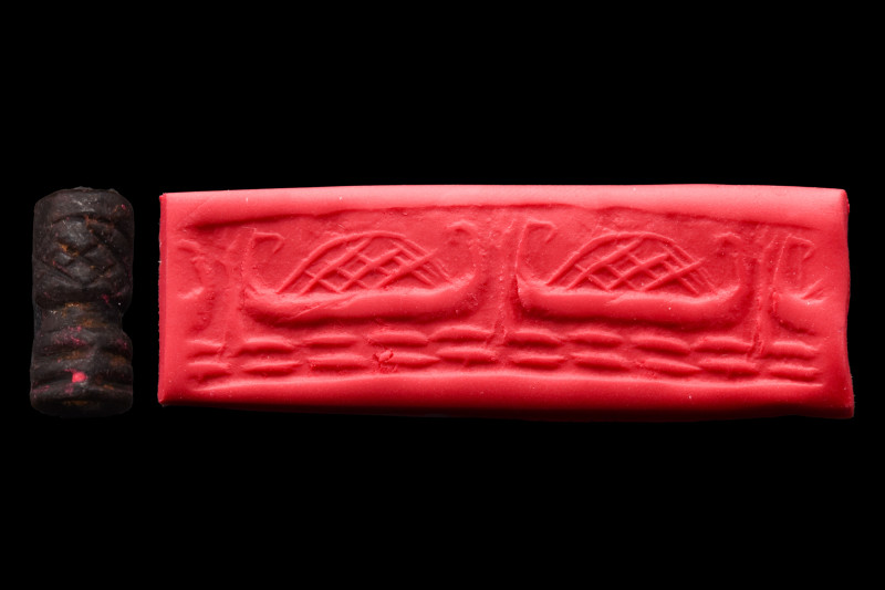Ca. 2200-2100 BC.
A black stone cylinder seal with a boat laden with cargo on wa...