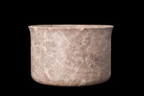Ca. 2nd millennium BC.
A stone vessel characterized by its cylindrical shape, featuring straight walls that rise vertically from a flat base. The basi...