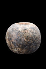 Ca. 1st millennium BC.
A carved hardstone ball-type mace head, having central shafting holes. Scattered areas of surface deposits. Intact, and in exce...
