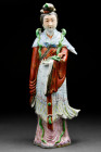 Ca. Late 19th - 1st half of 20th Century AD.
A large porcelain female figure, glazed in multicolor, wearing traditional costume. The lady holds a flow...
