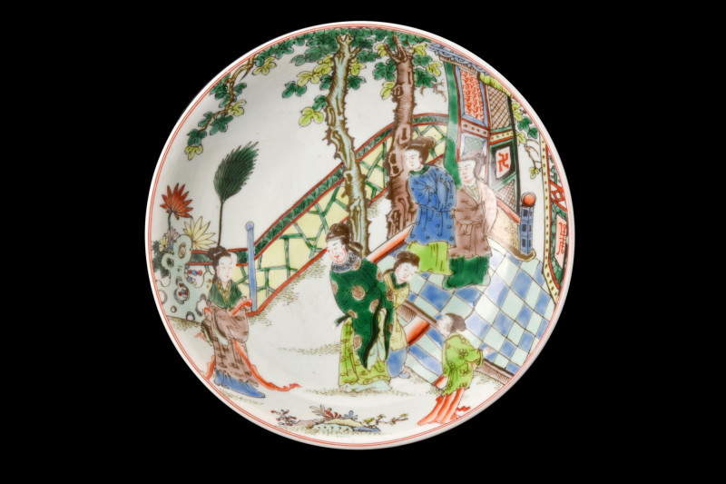 .
A porcelain plate depicting a scene of court ladies in a garden setting. The u...