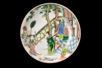 .
A porcelain plate depicting a scene of court ladies in a garden setting. The use of colour and composition in the painting creates a sense of tranqu...