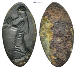 Female figure standing left, playing double flute. Possibly ringstone. (18mm, 0.66 g)