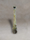 An antique Roman translucent-glass unguentary. It has an elongated pyriform body with a small narrowing at the base of the cylindrical neck and an inw...