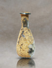 Introducing a remarkable flask from Eastern Mediterranean Roman production, meticulously crafted from translucent glass. This captivating artifact fea...