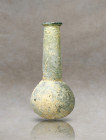Discover the allure of this intact translucent unguentarium, crafted from pale Roman glass. Its exquisite design showcases vertical ribs that graceful...