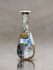Uncover the captivating charm of an ancient Roman bottle, skillfully fashioned from pale green glass. This remarkable artifact showcases a distinctive...