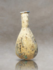 Immerse yourself in the ancient Roman world with this remarkable blown glass artifact, meticulously crafted from delicate pale glass. Its small pirifo...