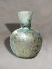 Experience the timeless elegance of an ancient Roman mould-blown dropper flask, meticulously crafted from delicate pale glass. This exceptional artifa...