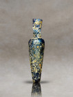 Eastern Mediterranean, Roman Period, circa 4th century AD. Blue-colored glass with a full iridiscenced body.Blown Amphora shaped perfume bottle of a r...