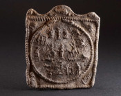 A ROMAN DANUBIAN RIDER LEAD VOTIVE PLAQUE Circa 3rd-4th century AD. Rectangular ‘Mystery Plaque’ with twisted border and wavy top; circular central me...