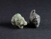 TWO ROMAN BRONZE FIGURAL APPLIQUES Circa 2nd-3rd century AD. One in the shape of a lion's head, remains of an iron stud on the reverse; the other depi...