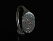 A BYZANTINE BRONZE RING WITH A BIRD Circa 6th-9th century AD. With an oval bezel depicting a stylised bird standing left. Ring size 56 (EU)

Ex priv...