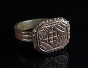 A LATE MEDIEVAL OR EARLY MODERN BRONZE RING Circa 15th-16th century AD. With a rectangular bezel with ornamental decoration and a central cross. Ring ...