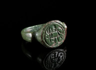 LATE ANTIQUE/EARLY BYZANTINE BRONZE RING WITH A WARRIOR Circa 4th-6th century AD. Ring with offset shoulders and round, raised bezel depicting a highl...
