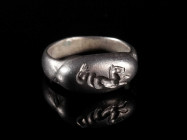 A ROMAN SILVER RING WITH A HIPPOCAMPUS Circa 2nd-3rd century AD Small ring with a raised oval bezel depicting a Hippocampus (Seahorse) right. Ring siz...