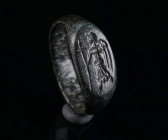 AN EARLY BYZANTINE BRONZE RING SHOWING AN ANGEL WITH CROSS Circa 6th-7th century AD. With an oval bezel depicting an angel advancing left with a long ...