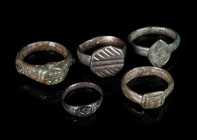 A GROUP OF FIVE BYZANTINE/EARLY MODERN BRONZE RINGS Circa 9th-16th century AD. Small rings; all with decorated bezel. Ring sizes 38-47 (EU)

Ex priv...