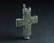 A BYZANTINE BRONZE RELIQUARY CROSS WITH A SAINT Circa 10th-12th century AD. One half of a reliquary cross (enkolpion) depicting a saint with his hands...