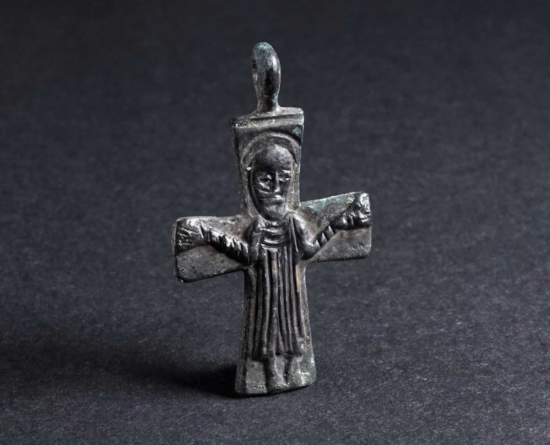 A BYZANTINE BRONZE CROSS PENDANT WITH A SAINT Circa 9th-11th century AD. Depicti...