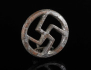 A ROMAN TINNED BRONZE SWASTIKA BROOCH Circa 2nd-3rd century AD. With four clockwise rotation arms within a circular frame; much of the original tinnin...