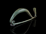 AN IRON AGE/EASTERN CELTIC BRONZE BOW BROOCH Circa 4th-3rd century BC. La Tène Type brooch, Early-Middle La Tène Period. Made of one piece with spring...