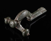 A LATE ROMAN BRONZE CROSSBOW BROOCH Circa 4th century AD. The foot with ring and dot decoration; attractive dark green patina with very minor pitting;...