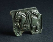 A BYZANTINE BRONZE BELT BUCKLE WITH A GRIFFIN Circa 9th-11th century AD. Square plate from a belt-buckle; in relief, a griffin or winged horse stridin...