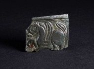 A BYZANTINE BRONZE BELT BUCKLE WITH A GRIFFIN Circa 9th-11th century AD. Square plate from a belt-buckle; in relief, a griffin or winged horse stridin...