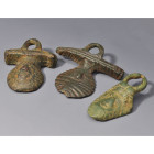 ARQUEOLOGÍA. ROMA. Lote de 3 apliques de asa de sítula (ss.I-IV d.C.). Bronce. Longitud de 3,4 a 7,5 cm.