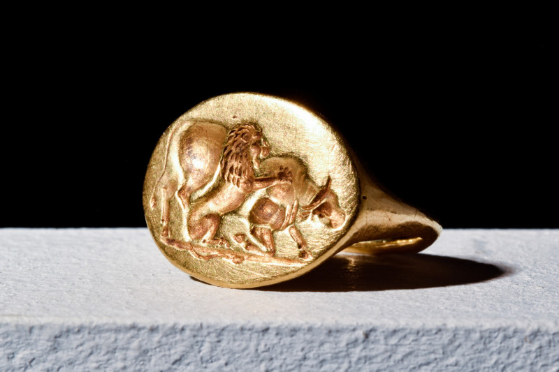 SCARCE GREEK HELLENISTIC GOLD RING WITH LION ATTACKING BULL

 Ca. 400 BC
 A g...