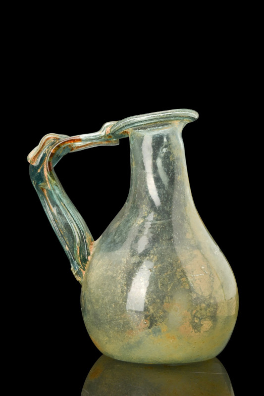 ROMAN GLASS HANDLED BOTTLE

 Ca. 100-300 AD
 A blue-green blown glass bottle ...