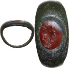ROMAN RING WITH 'GRILLOS' Bronze ring with carnelian intaglio engraved with 'grillos' (two joined faces). Roman period, 1st-2nd century AD. Gem 9 x 7 ...