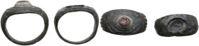 TWO ROMAN BRONZE RINGS Roman period, c. 2nd-3rd century AD. Lot of two (2) bronze rings, one with a lovely iridescent glass paste. Inner size: both 17...