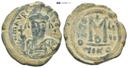 Maurice Tiberius AD 582-602. Nikomedia Follis AE (11.95 Gr. 30mm) 
Helmeted and cuirassed bust facing, holding globus cruciger and shield 
Rev. Large ...
