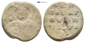Byzantine Lead Seal (18mm, 5.53 g) Obv: Nimbate facing bust of Saint, holding spear over his right shoulder and resting shield on his left arm. Rev: L...