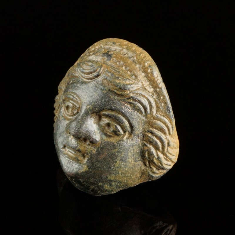 Roman Face Mount
1st-3rd century CE
Bronze, 28 mm
Expressional young face.
E...