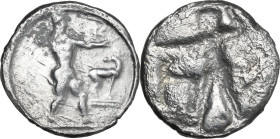 Greek Italy. Bruttium, Kaulonia. AR Stater, 475-470 BC. Obv. Apollo striding right, brandishing branch, small daimon running on outstretched arm; to r...