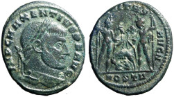 MASSENZIO (309-312) Follis per Ostia. D/ Testa laur. a ds. R/ I Dioscuri stanti tengono i cavalli per le redini; in basso al centro, la lupa e i gemel...