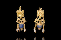 HELLENISTIC GOLD PAIR OF FILIGREE EARRINGS WITH DOLPHINS

 Ca. 4th century BC
 A matched pair of earrings, each featuring a hook with a flower-shap...